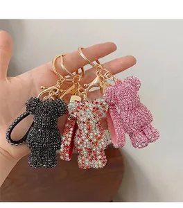 Detailed view of three rhinestone-encrusted bear figurines on golden metal keychains