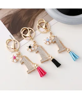 Gros plan de porte-clés chiffre un avec strass brillants, perles et glands en cuir