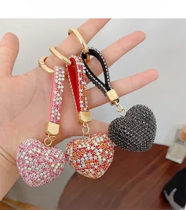 Macro shot of shimmering rhinestone heart keychains in pink, black and gradient red yellow