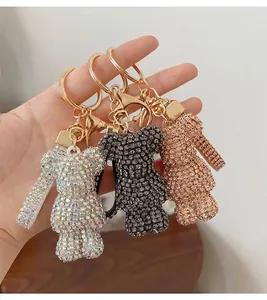 Detailed close-up of rhinestone bear keychains in iridescent, black and rose gold finishes