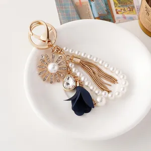 Elegant sunflower keychain with pearl beads, blue floral charm and golden fringe tassel