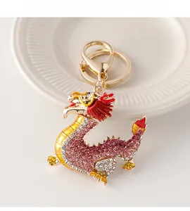 Détail du porte-clés dragon orné de strass roses et rouges sur une coupelle en céramique
