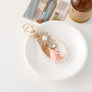 Exquisite sunflower keychain with pearls, crystals, tassels, and golden metal details