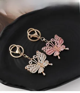Detailaufnahme von rosa und weißen Schmetterlings-Schlüsselanhängern mit Kristallbesatz