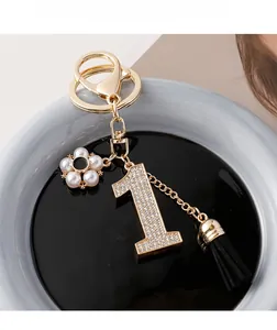 Détail du porte-clés numéro 1 en cristal avec fleur en perles et pompon en daim noir
