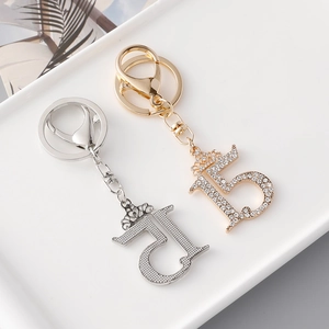 Elegant number 15 keychains with crown detail in gold rhinestone and silver metal