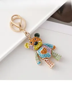 Détail d'un porte-clés ours en peluche coloré avec strass brillants et monture dorée