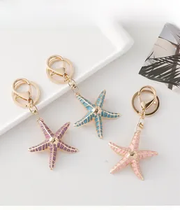 Detailed close-up of starfish keychains in purple, blue and pink with gold metal clasp