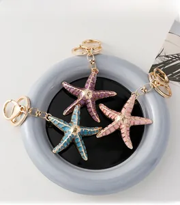 Detail of starfish keychains in macaron colors with gold metal lobster clasp and ring