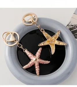 Macro view of starfish keychains with pink enamel and golden hollow texture details