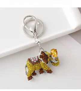 Macro detail of elephant keychain with sparkling yellow rhinestones on a white plate