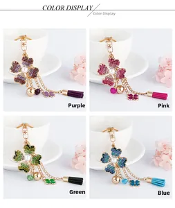 Detail showing four leaf clover keychains with crystals and tassels in multiple colors
