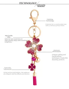 Detail of pink rhinestone clover keychain with metallic tassel and small bell accessory