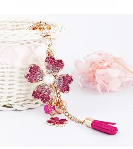Detail of four-leaf clover keychain with pink rhinestones, pearl, and silk tassel