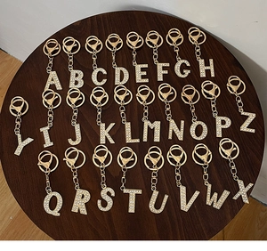 Macro view of full A-Z alloy alphabet keychains with sparkling white rhinestones