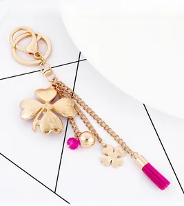 Detail of gold clover keychain with pink tassels, beaded charms and lobster clasp
