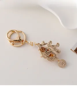 Detail of a golden Fu character keychain with rhinestones and ancient coin charm