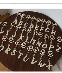 Close-up of sparkling 26 gold-tone initial keychains with rhinestones and lobster clasps