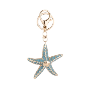 Starfish shaped keychain with light blue enamel and golden metal frame on white background