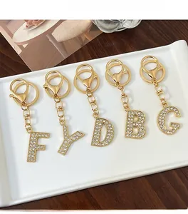Close-up of gold alloy alphabet keychains F Y D B G with sparkling white rhinestones