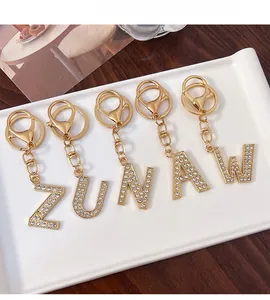 Detailed view of Z, U, N, A, W letter keychains with sparkling rhinestones and gold finish