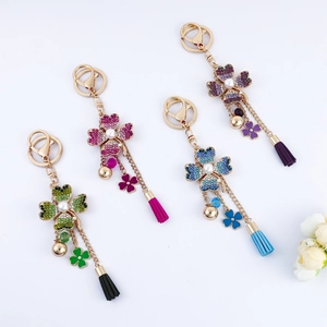 Floral keychain with rhinestones, pearl center, colorful tassels and golden bells