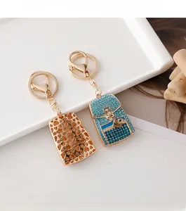 Close-up of heart-shaped mini bag keychains with gold plating and blue rhinestones
