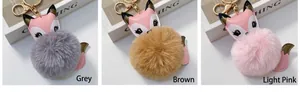 Tre portachiavi a pompon volpe in grigio, marrone e rosa con anello in metallo oro