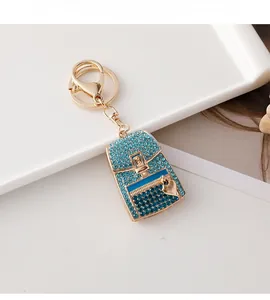 Detail of blue rhinestone heart backpack keychain with gold lobster clasp on white tray