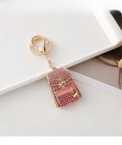 Macro shot of pink backpack keychain with sparkling rhinestones and golden metal hardware