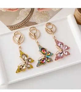 Vue détaillée de porte-clés papillon en strass colorés sur un plateau en céramique