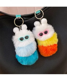 Detailed view of colorful plush caterpillar bag charms on a black leather backpack