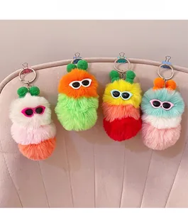 Macro detail of plush caterpillar monster keychains with sunglasses and metal clips