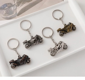 Detailed top view of four metal motorcycle keychains in bronze, silver, and gunmetal finishes