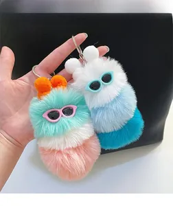 Close-up of colorful plush caterpillar keychain with sunglasses accessory and fluffy fur