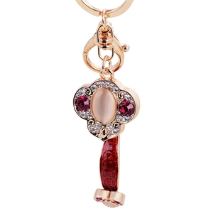 Rose gold Ruyi keychain with moonlight stone and red enamel coin charm on white background