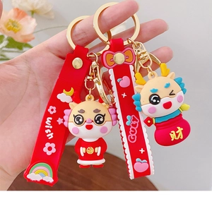 Detail of red cartoon dragon keychain with festive gold charm and lucky wish strap