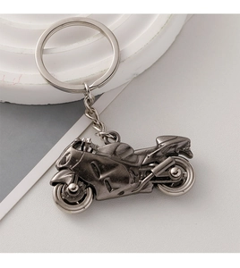 Detailed close-up of a vintage silver motorcycle keychain with metallic ring and chain link