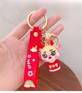 Close-up of red cartoon dragon keychain with silicone wrist strap and golden buckle