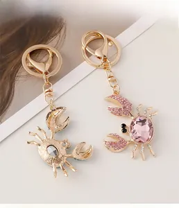 Gros plan sur les porte-clés crabe doré sertis de diamants et pierres roses brillantes