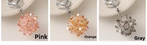 Trois porte-clés en perles de cristal rose, orange et gris avec anneau métallique