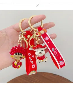 Close-up of festive red cartoon keychains with gold metal clasps and PVC wrist straps