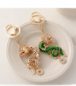 Detail of gold hollow and green enamel dragon keychains with crystals and coins