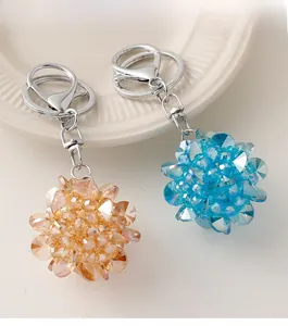 Détail de porte-clés boule de cristal en ambre et bleu sur une assiette blanche