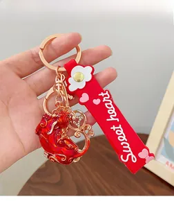 Close-up of festive red and gold mythical beast keychain with a Sweet Heart wrist strap