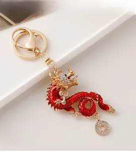 Detail view of a golden dragon keychain with red enamel scales and sparkling rhinestones