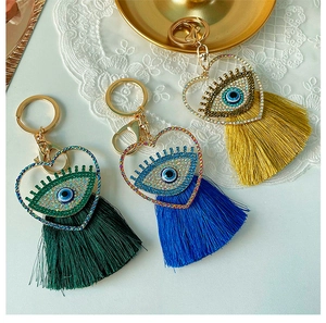 Vue détaillée de porte-clés œil maléfique en forme de cœur avec pompons en plusieurs couleurs