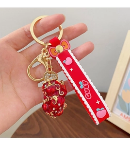 Detail of red Pixiu keychain with gold enamel, soft silicone strap and sparkling accents