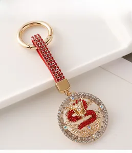 Detailed close-up of golden dragon keychain with red rhinestones and sparkling wrist strap