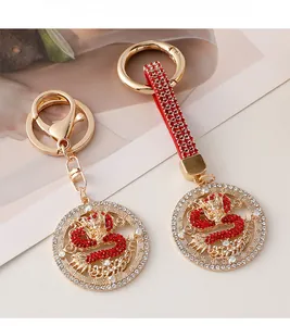 Detail of dragon keychains with red crystals and gold metal finish in Chinese style
